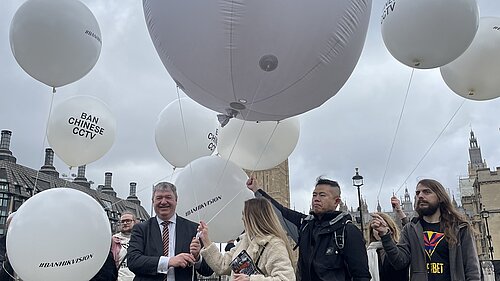 Alistair Carmichael and Others standing with large white balloons