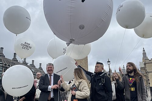 Alistair Carmichael and Others standing with large white balloons